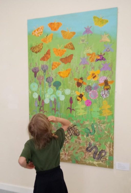 Girl stood in front of a painting of habitat art