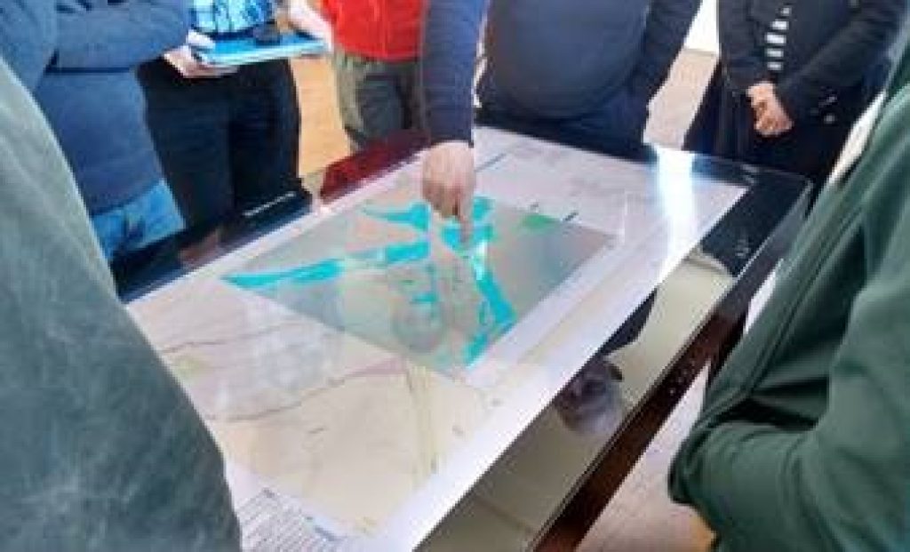 JBA interactive model with people gathered around it