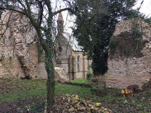 High walls that remain from the 13th century Cistertian abbey, with the Victorian Church in the background.