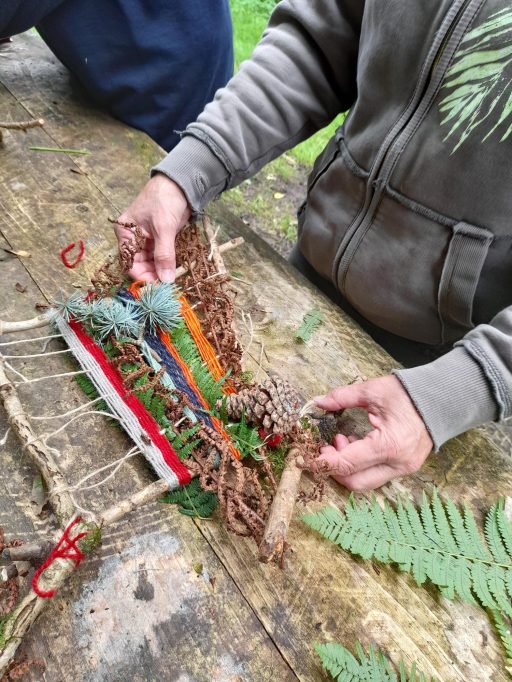 Hands working on a nature loom