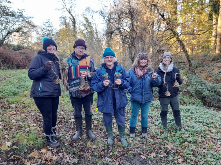 1 man and 4 women stood in the woods holding wicker