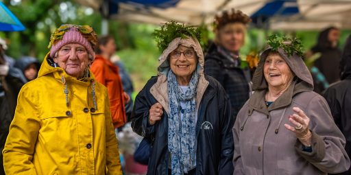 A group of women in headdresses made out of leaves and ferns