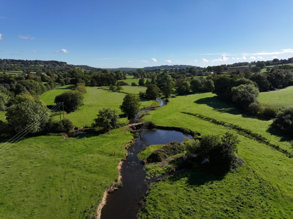River winding its way through grassland with bridge crossing place